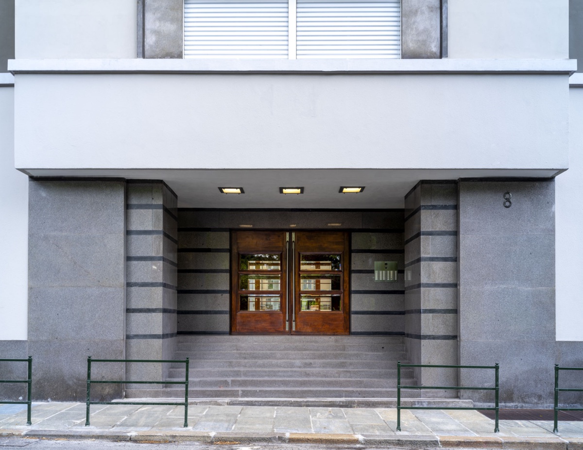 Rationalist granite entrance with wooden doors — a project by the firm